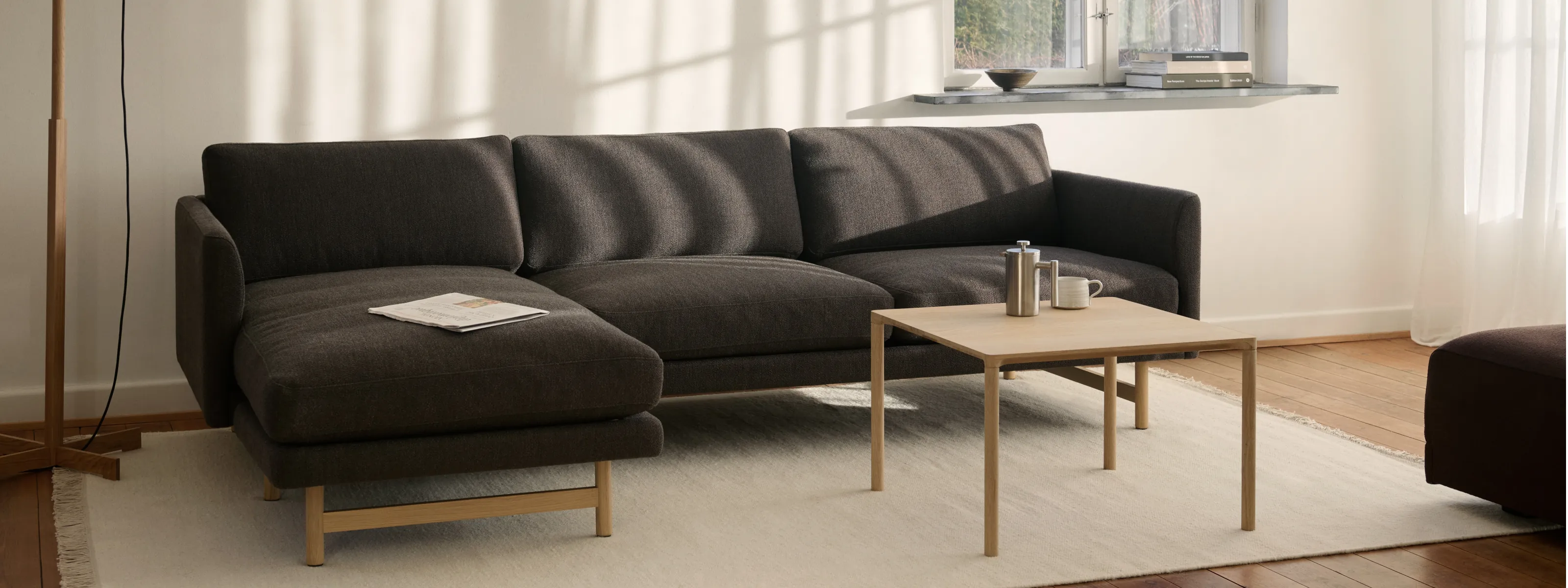 Fredericia Lounge-Setting mit skandinavischem Sofa, Holzdetails und sanftem Tageslicht
